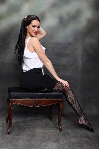 Menina europeia bonita com cabelo preto longo posando em estúdio sobre tela de fundo. Estilo, tendências, conceito de moda. - Foto, Imagem