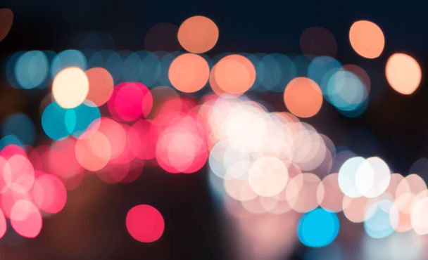 Kleurrijke auto verkeer licht bokeh op straat 's nachts, abstract wazig gloeien stad achtergrond - Foto, afbeelding