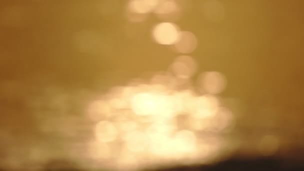 Bokeh Sonnenblendung Reflexion des Sonnenaufgangs Sonnenuntergang Licht in der Wasseroberfläche. Sonnenstrahlen flackern im Ozean.Golden schimmernde Meereswellen in der Sonne Abstrakte verschwimmen unscharf Bokeh Hintergrund Erstaunlich goldenes Licht - Filmmaterial, Video