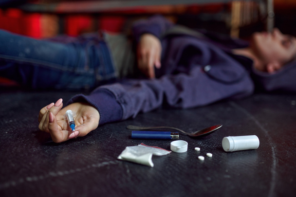 Наркоманія жінка лежить на підлозі в джинсі, роздягається інтер'єр на фоні, передозування. Проблема наркоманії, вічна депресія незграбних людей
 - Фото, зображення