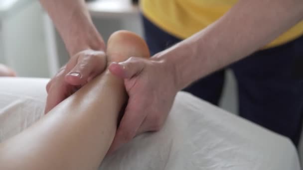 massagista masculino faz massagem relaxante nos pés com óleo - Filmagem, Vídeo