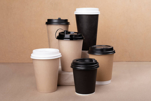 Lot of drinking paper coffee cups on cardboard background - Foto, Imagem