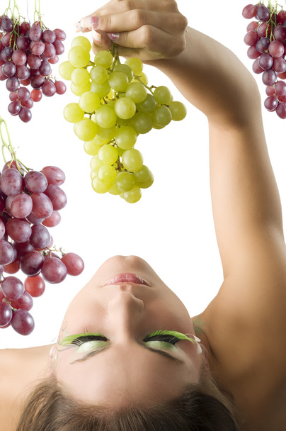 girl with her head down keeping some green grape from top - Foto, Bild