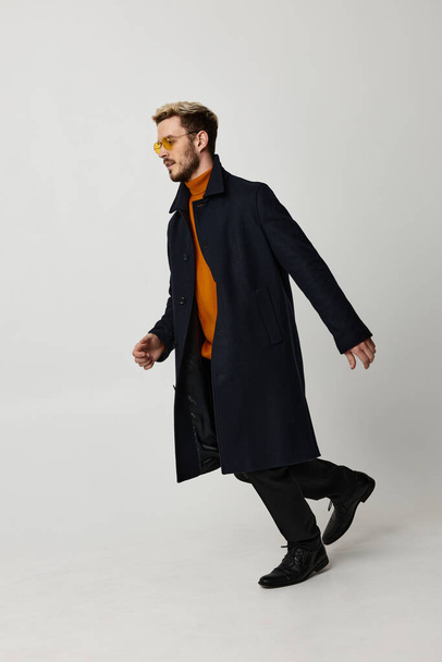 mężczyzna w czarny płaszcz żółty okulary moda nowoczesny ruch - Zdjęcie, obraz
