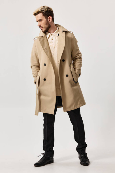 κομψό άνθρωπος σε μπεζ παλτό και παντελόνι μόδα στυλ παπούτσια μοντέλο - Φωτογραφία, εικόνα