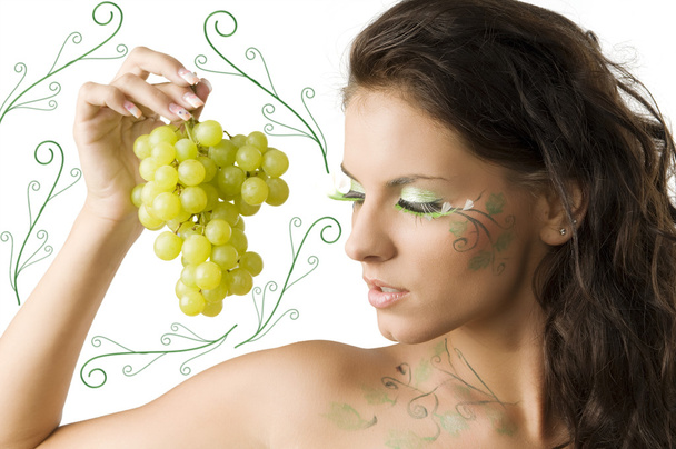 nice brunette with bodypaint and green eyelashes looking a grape - Photo, Image