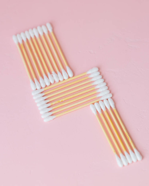 environmentally friendly bamboo and cotton cotton buds on a pink background, bamboo toothbrushes for adults and children. human personal hygiene products without harming the environment - Фото, изображение
