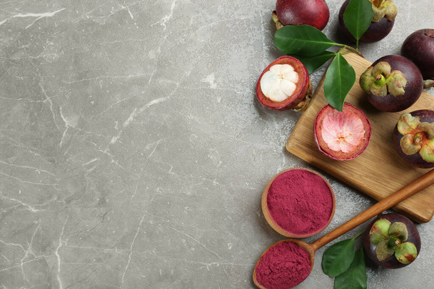 Purple mangosteen powder and fruits on grey marble table, flat lay. Space for text - Foto, immagini