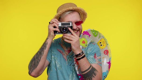 Hombre fotógrafo turístico tomando fotos en cámara retro y sonriendo, viajes, vacaciones de verano - Foto, imagen