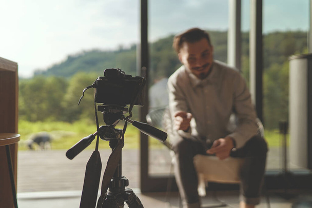 Vista frontal da entrevista de gravação de empresário de sucesso com câmera e tripé - Foto, Imagem