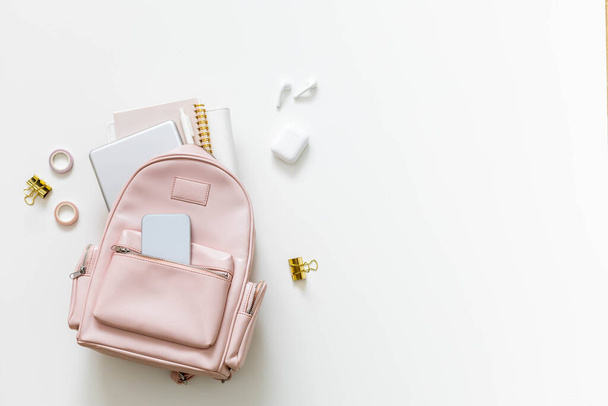 Top view elegancki różowy plecak studencki pełen dostaw odizolowanych. Powrót do koncepcji szkoły - Zdjęcie, obraz