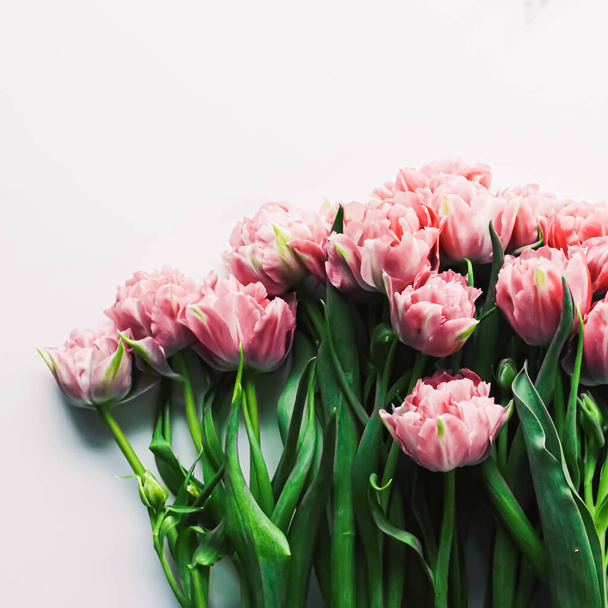 Весенние цветы на мраморном фоне в качестве праздничного подарка, поздравительной открытки и цветочного украшения - Фото, изображение
