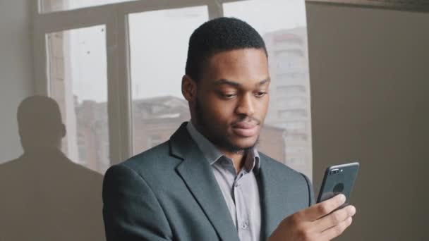 African American guy look at cell phone screen. Businessman mobile technology user black man working in digital app receiving sms message reading news searching information online, texting messages. - Footage, Video