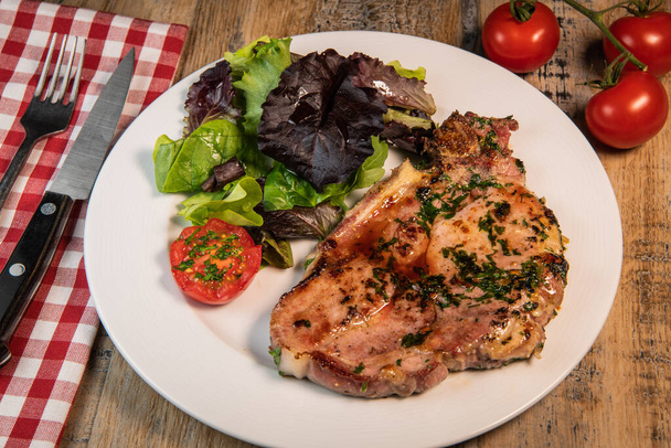 Recipe for grilled pork chop, maple syrup and fresh cilantro marinade, parsley, garlic, served with a salad. - Fotoğraf, Görsel