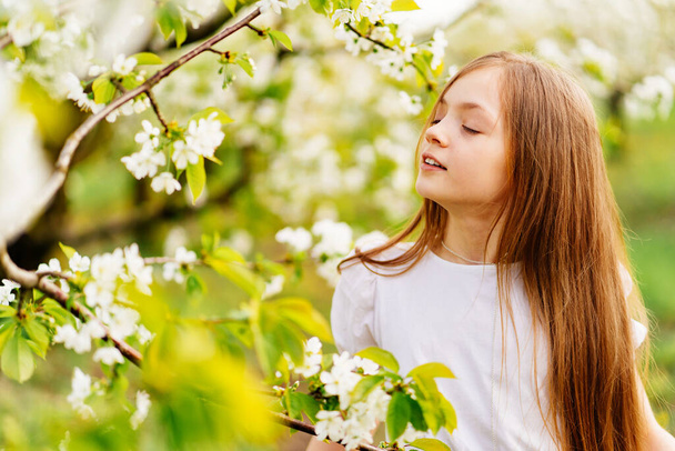 Beautiful teenage girl with a branch of a flowering tree. natural cosmetics - Fotó, kép