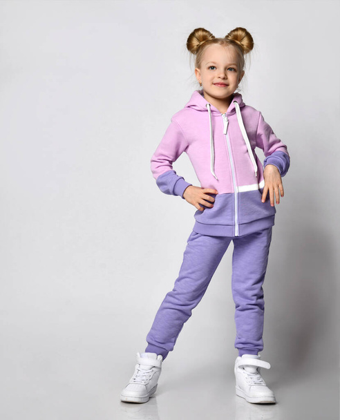 Girl in pink violet sportive suit posing for camera studio shot - Photo, image