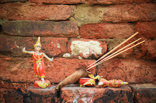 Budist tapınağı ile antik tuğla duvar nimet için Tay dans eden bebek. - Fotoğraf, Görsel