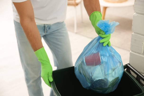 Man throwing garbage bag into bin at home, closeup - Zdjęcie, obraz