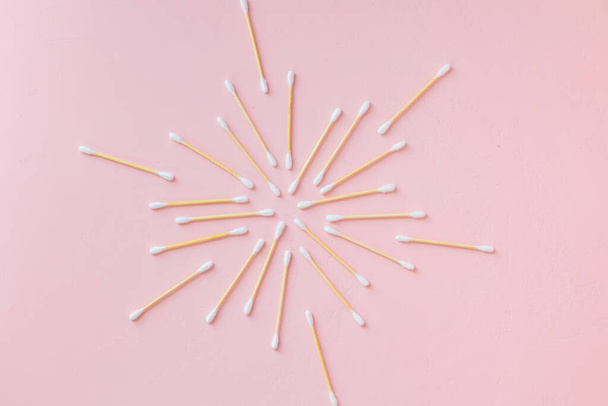 environmentally friendly bamboo and cotton cotton buds on a pink background, bamboo toothbrushes for adults and children. human personal hygiene products without harming the environment - Foto, imagen