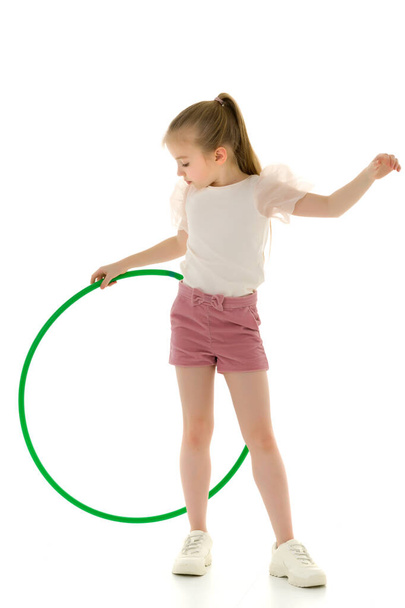 The little girl turns the hoop. - Foto, Bild