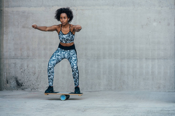 Afro athletic woman doing exercise outdoors. - 写真・画像