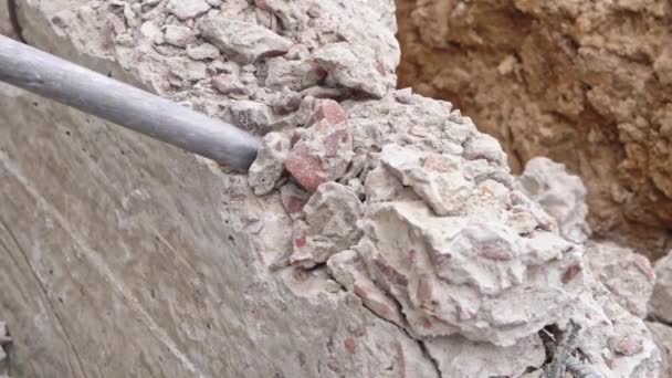 Demolición de un martillo neumático de una estructura de hormigón en un sitio de construcción de cerca, vista superior - Imágenes, Vídeo