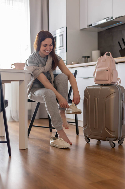 Moderne koffer vol met spullen, handtas en strohoed. Bagageruimte klaarmaken om te reizen - Foto, afbeelding