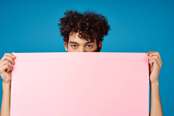 guy with curly hair holding pink Poster mockup Coffee Space - Photo, Image