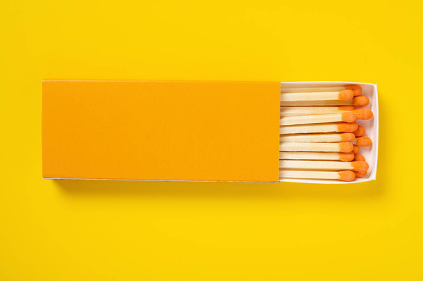 orange color matchbox and orange match sticks on a orange background - Foto, Imagen