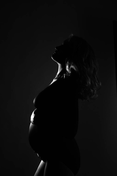 Young beautiful pregnant woman standing on pink background - Fotoğraf, Görsel