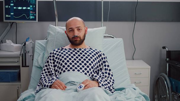 Potrait of sick man wearing nasal oxygen tube having respiratory disease l - Zdjęcie, obraz