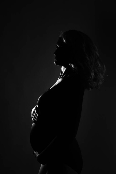 Young beautiful pregnant woman standing on pink background - Fotó, kép