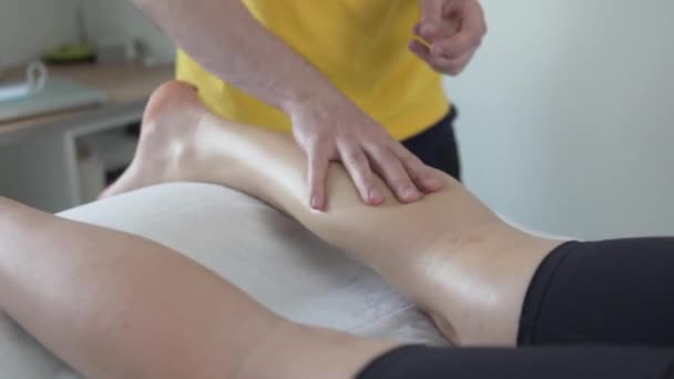 Professionelle Masseur massiert eine Frau Beine - Filmmaterial, Video