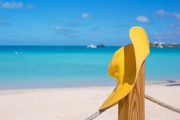 Yellow hat on the beach fence at caribbean island - Photo, Image