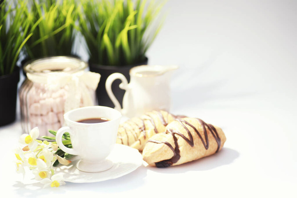 Γαλλικό πρωινό στο τραπέζι. Καφές κρουασάν με σοκολάτα και καράφα με κρέμα. Νωπά αρτοσκευάσματα και καφές χωρίς καφεΐνη. - Φωτογραφία, εικόνα
