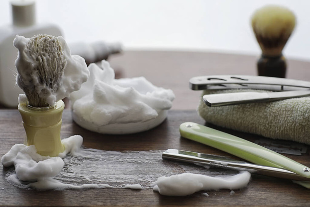 Shaving accessories on a wooden texture background. Tools. Disposable shaving machine, brush, foam hazard razor. - Photo, Image