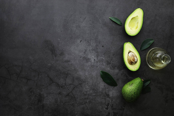 Avocado cooking recipes. Ripe green avocado on a wooden cutting board serving. - 写真・画像