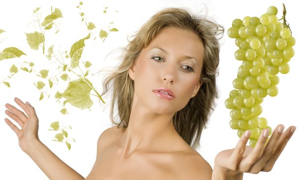 pretty and sensual blond girl with a big grape near and some flying leaves grape - Photo, Image