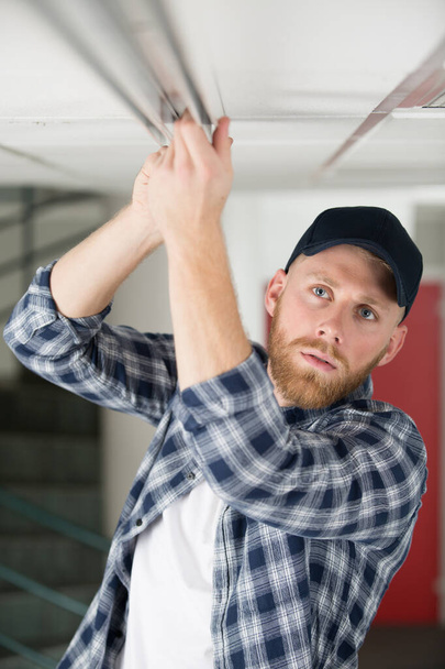 young guy repairs ceiling - Valokuva, kuva