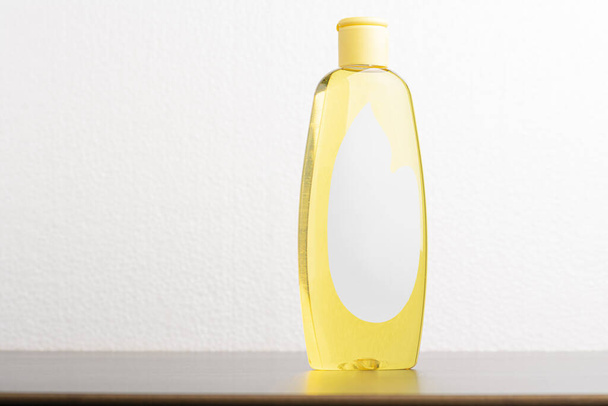 A closeup shot of a hair shampoo bottle in front of a light gray background - Fotoğraf, Görsel