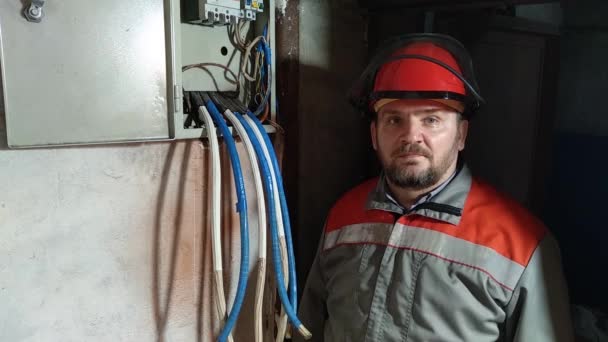 Electrician in a helmet. He covers his face with a protective mask. Arc flash face shields are generally worn to protect the face from molten metal or from arcing energy, and are a vital piece of PPE - Footage, Video