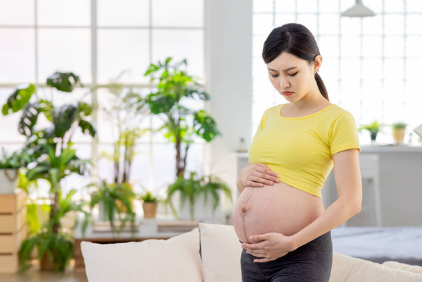 pregnant woman feel depression standing at living room  - Foto, immagini