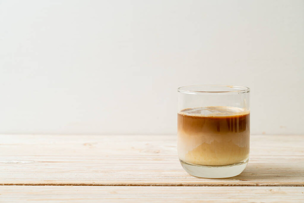 Dirty coffee glass, cold milk topped with hot espresso coffee shot - Zdjęcie, obraz