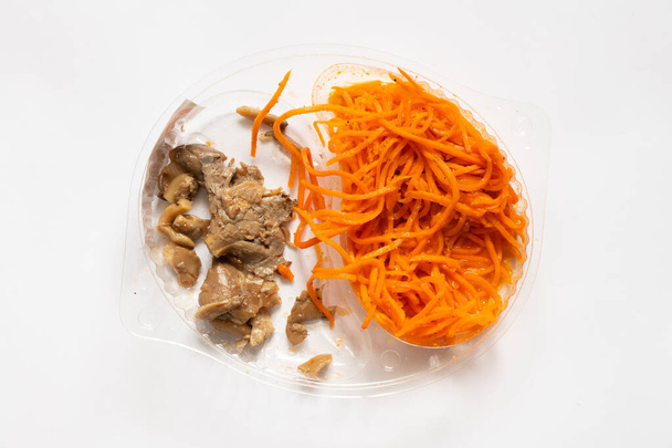 mrkev a houby naložené v plastové misce na bílém talíři zblízka - Fotografie, Obrázek