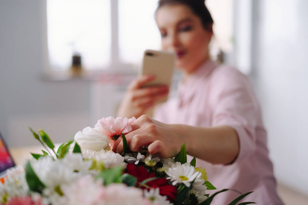 Woman taking picture flower composition on smartphone - Foto, Imagem