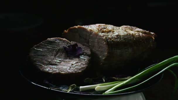 vlees met uien op een zwarte bord presentatie, spelen met licht - Video