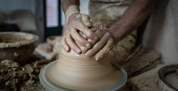 Potter hands gently working on pottery, closeup view - Foto, imagen
