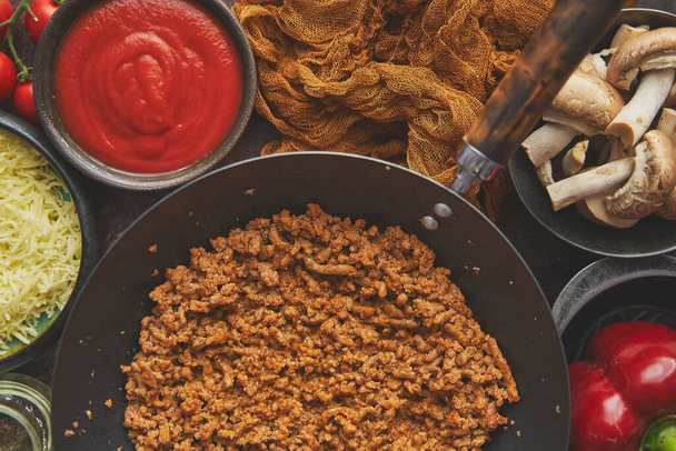 Ingredienti su un tavolo preparato per imbottitura di peperoni. Peperoni rossi, carne macinata, formaggio - Foto, immagini