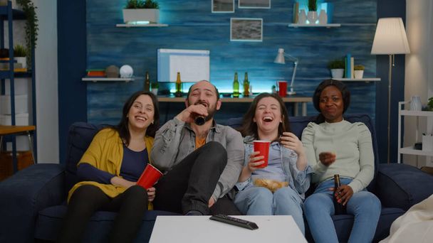 Multiethnische Freunde lachen, während sie einen Komödienfilm sehen und die gemeinsame Zeit genießen - Foto, Bild