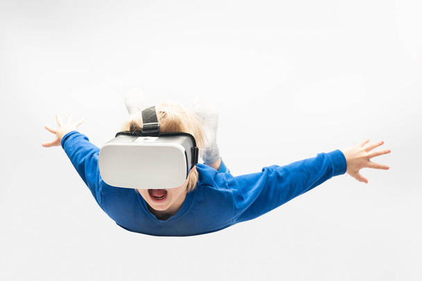 Little boy in virtual reality glasses falls from height. White background. Video games. - Fotografie, Obrázek